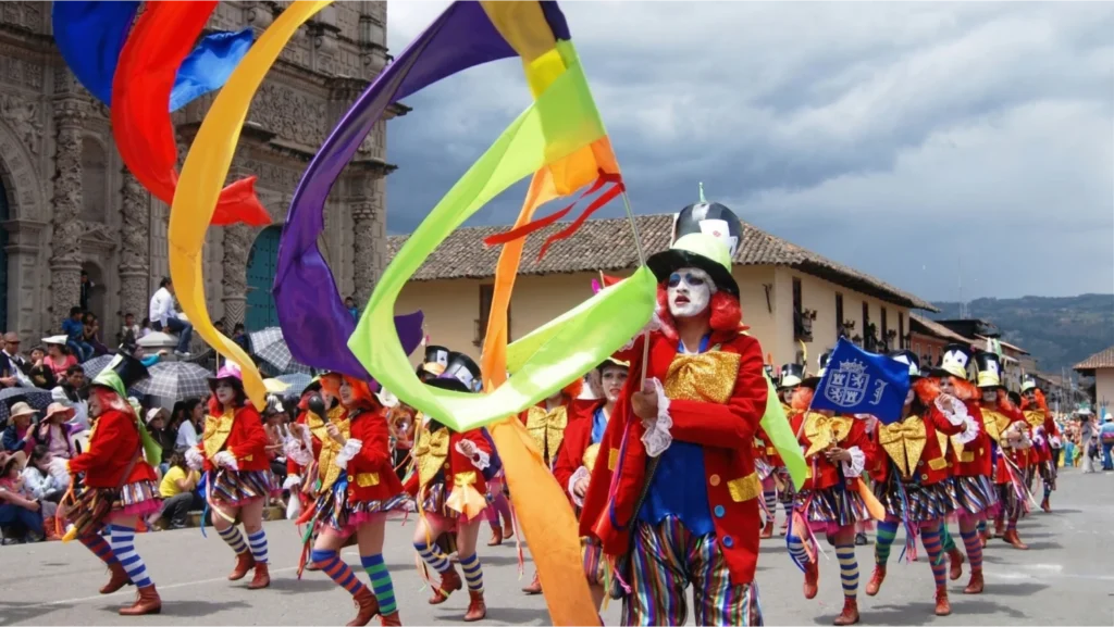 Desfile de danzantes con cintas de colores y trajes típicos en la Plaza de Armas durante el Carnaval de Cajamarca - Perú Tours